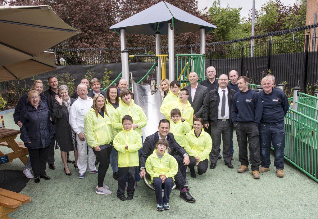 Pictured on the slide is Jonathan Fair, managing director of Stewart Milne Homes Central and clockwise from top left, Lucy, Anthony, Callum, Aiden, Abbie and Jamie. Behind are staff from COJAC and the team from Stewart Milne Homes who did the work.