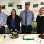 BAM staff celebrating anniversary with cake