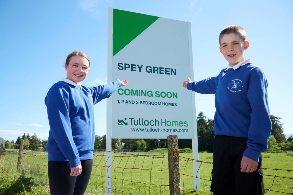 Kids standing by Spey Green development sign