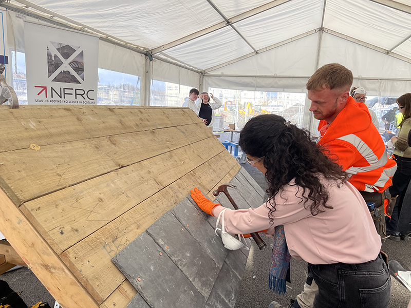 NFRC image. A student lays slate on a training rig during a skills demonstration at The Engine Shed, Stirling
