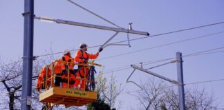 Engineers install overhead wires on railway line