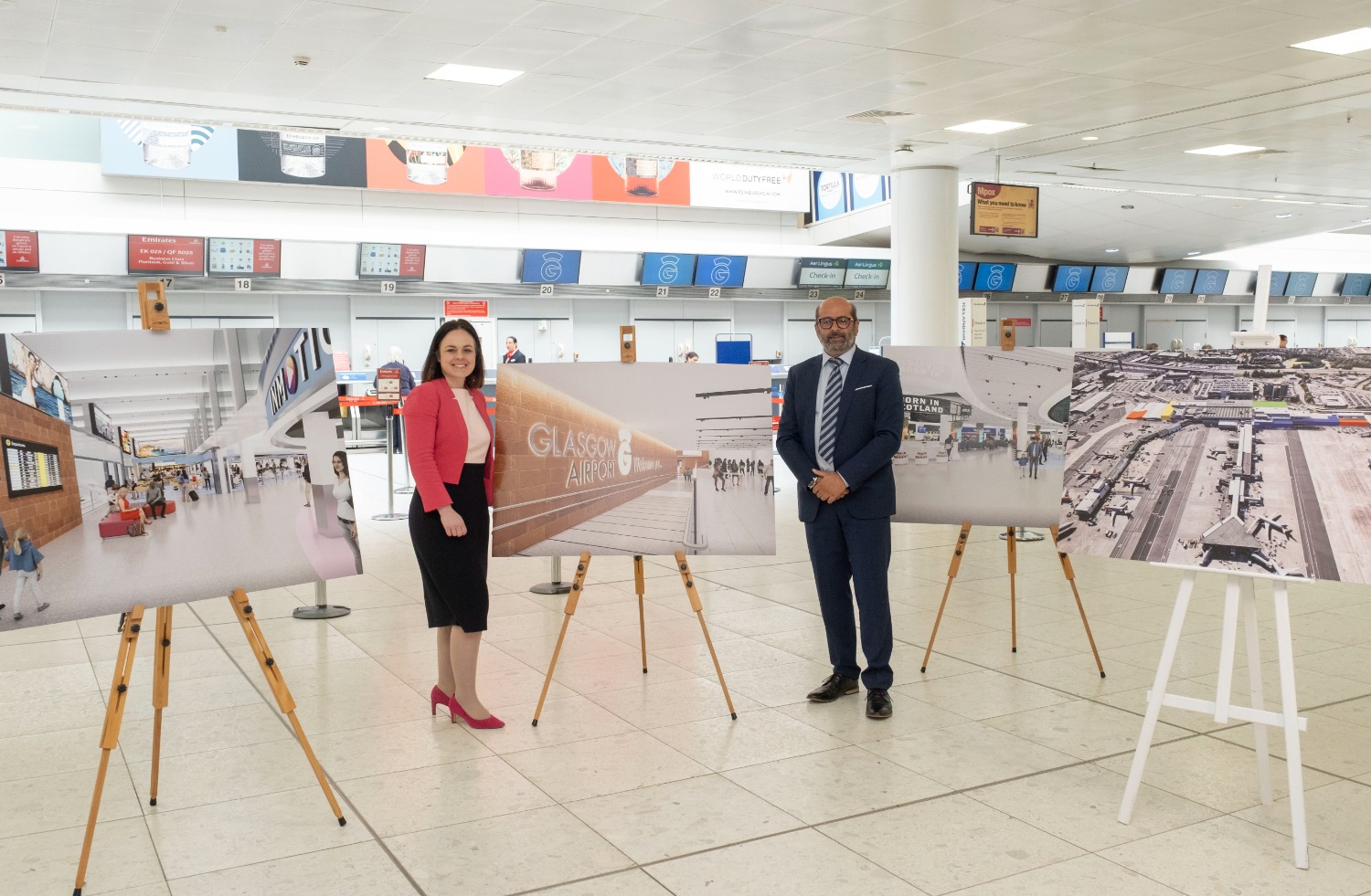 Kate Forbes and Kam Jandu stand in Glasgow Airport's main terminal alongside CGI images of the plans for the airport