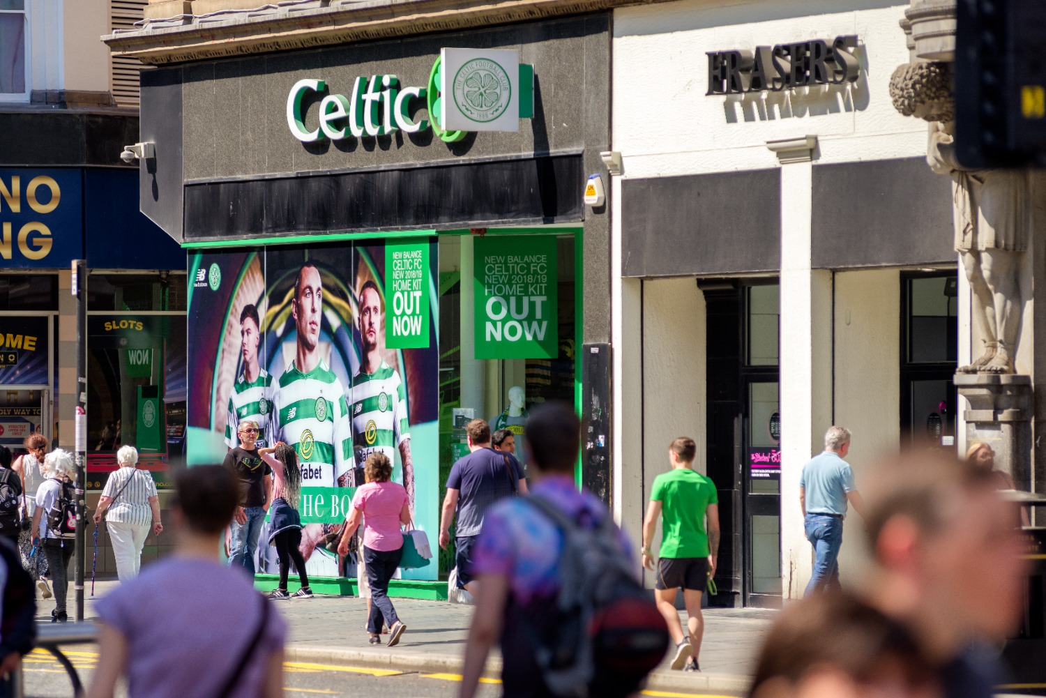 Crowds of people walking past Celtic store in Glasgow