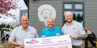 Participants stand with cheque