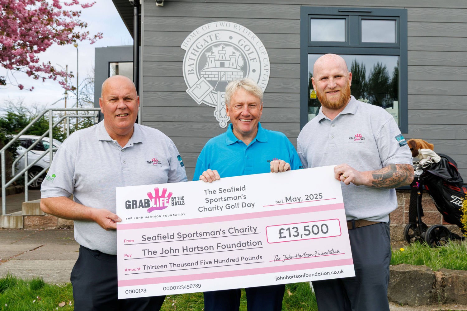 Participants stand with cheque