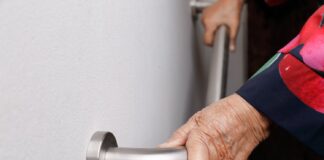 Elderly woman holding grab rail