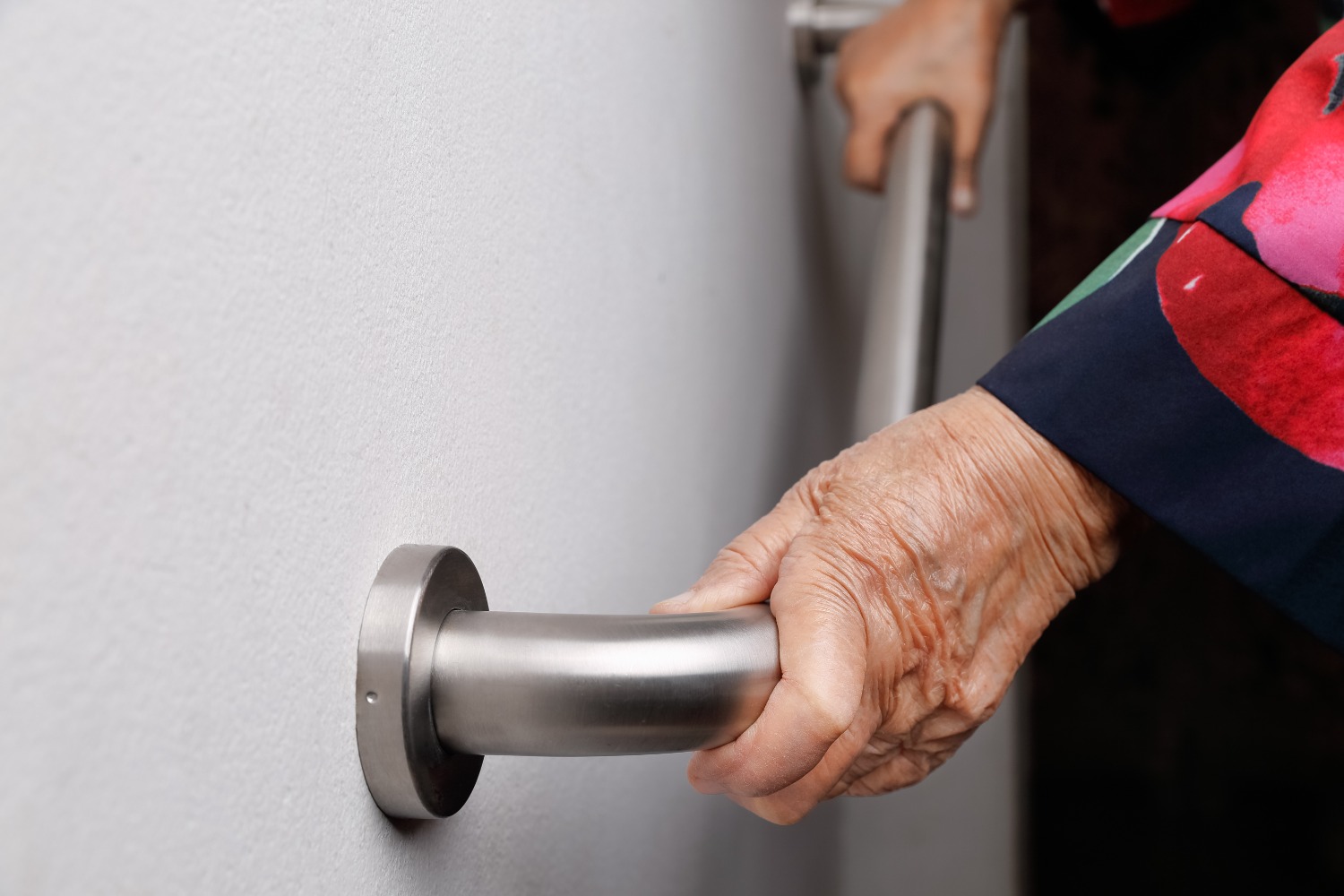 Elderly woman holding grab rail