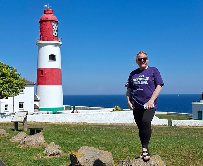 Charity fundraiser standing outside lighthouse