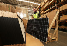 Construction worker holding solar panels