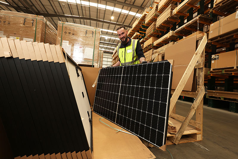 Construction worker holding solar panels
