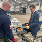 NFRC Scotland events help to drive skills agenda within roofing sector Kyle Stoddart of Compass Roofing Ltd showing MP Euan Stainbank how to cut slate