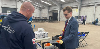 Kyle Stoddart of Compass Roofing Ltd showing MP Euan Stainbank how to cut slate