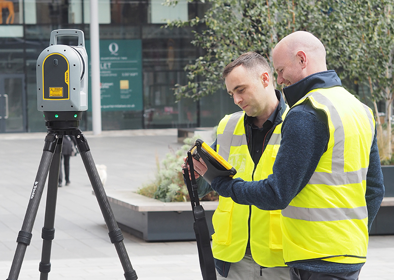 Construction workers carrying out geospatial measurement work