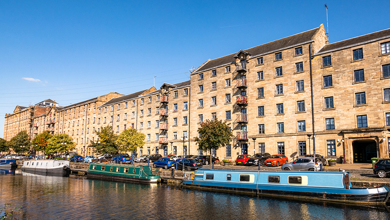 Narrowboats and cars outside buildings in Glasgow