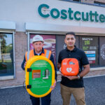 Housebuilder donates defibrillator in Greendykes, Edinburgh Taylor Wimpey health and safety advisor, Peter Goldie, with Aftaab Rafique, owner of Costcutter in Greendykes. Image credit: Chris Watt Photography