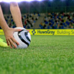 Football match with advertising hoardings in background