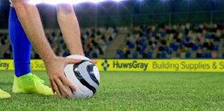 Football match with advertising hoardings in background