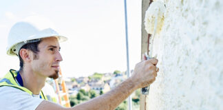 Worker painting outside of a house