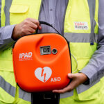 Construction worker holding defibrillator