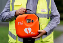 Construction worker holding defibrillator