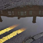 UK road markings ‘need to improve’ to unlock benefits of autonomous vehicles A tenement in a Glasgow street reflected in a puddle with double yellow lines on the road