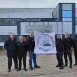 Construction workers holding banner depicting West Highland Way charity trek