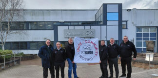 Construction workers holding banner depicting West Highland Way charity trek