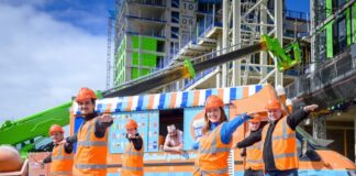Construction workers participating in yoga session with ice cream truck in background