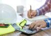Calculator and construction equipment. Image credit: Shutterstock