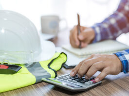 Calculator and construction equipment. Image credit: Shutterstock