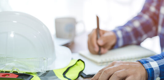 Calculator and construction equipment. Image credit: Shutterstock