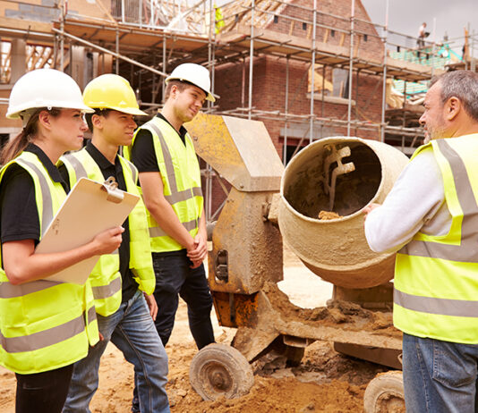 Partnership working tipped to help attract fresh talent Builder using cement mixer on site with apprentices
